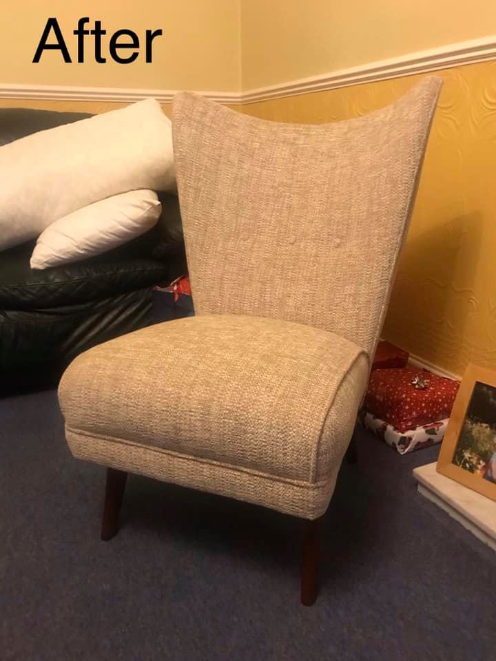 A dining room chair with beige upholstery in a yellow room