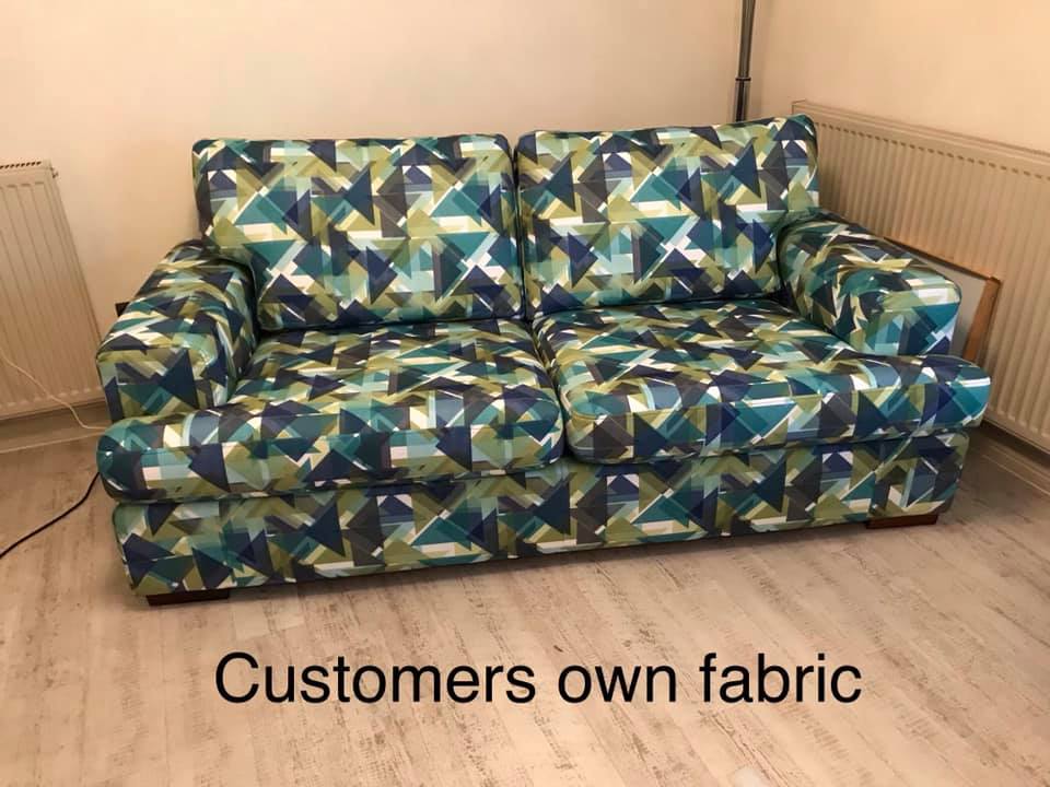 Blue and green geometric patterned sofa on hardwood floor