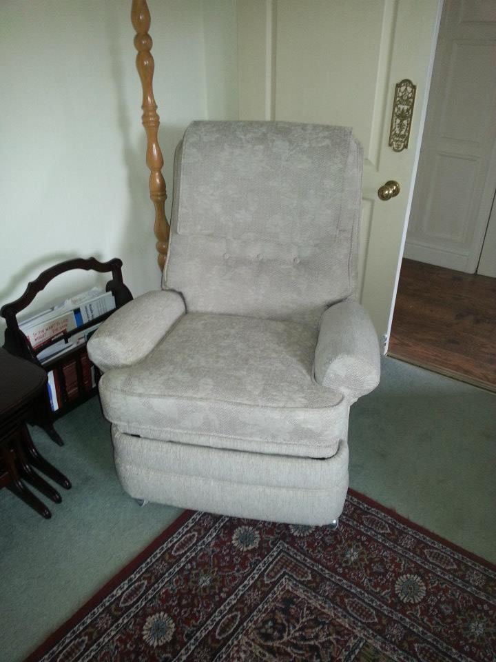 Light coloured armchair in a room with green carpet