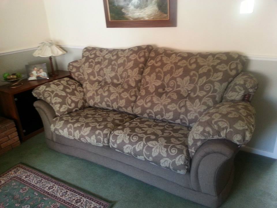 Patterned sofa against a wall with a picture hanging above it