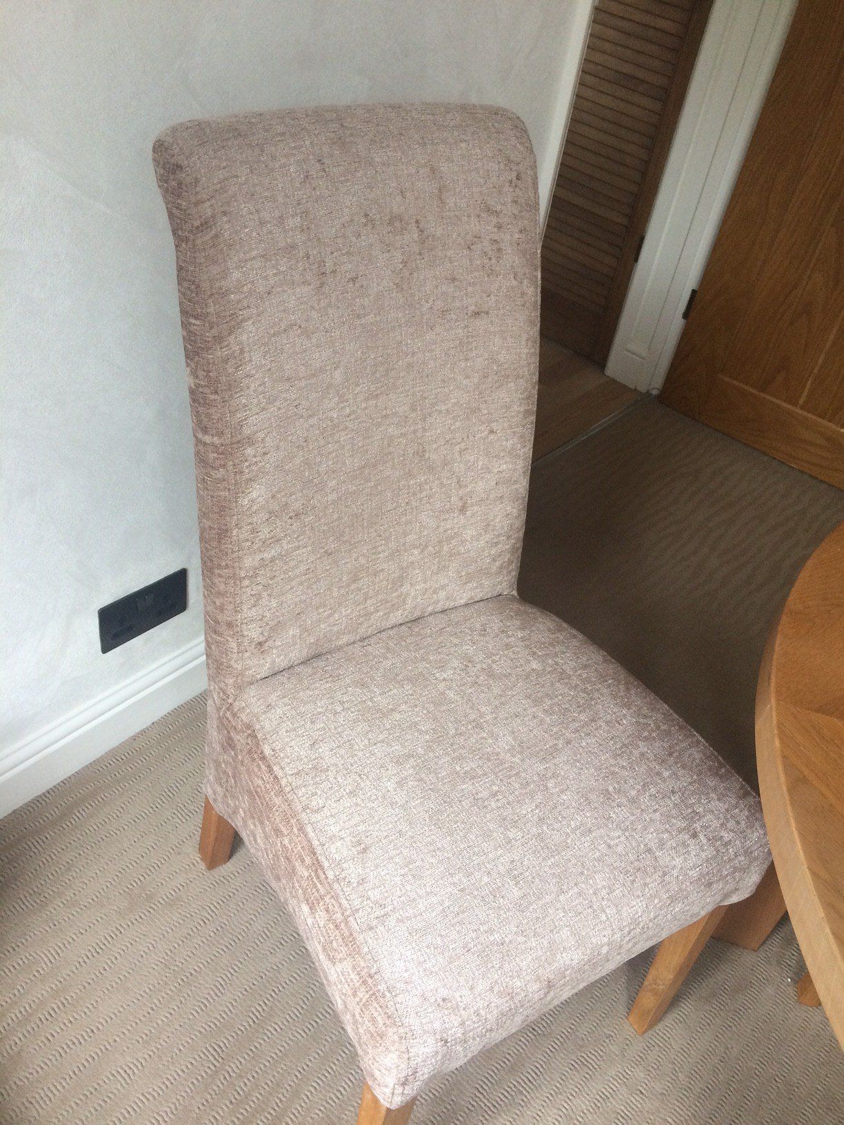 Upholstered dining room chair next to wall