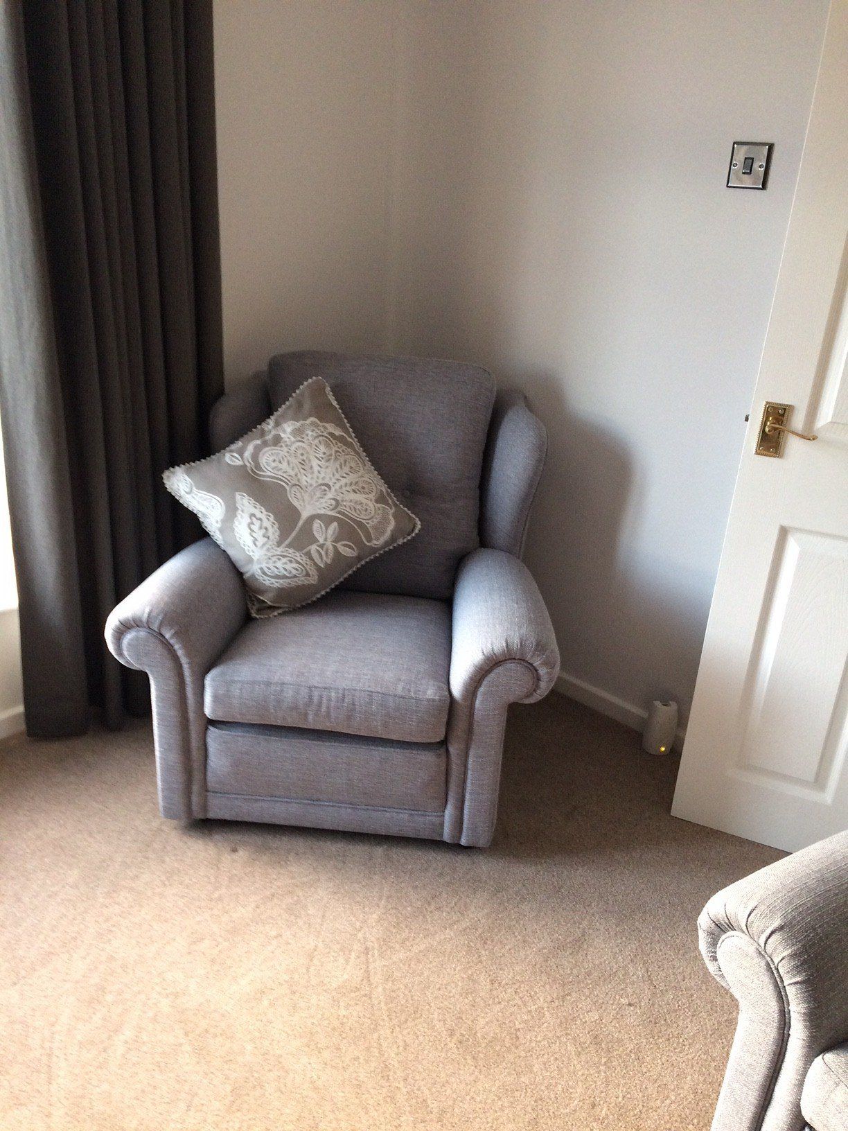 Grey armchair in a corner with cushion