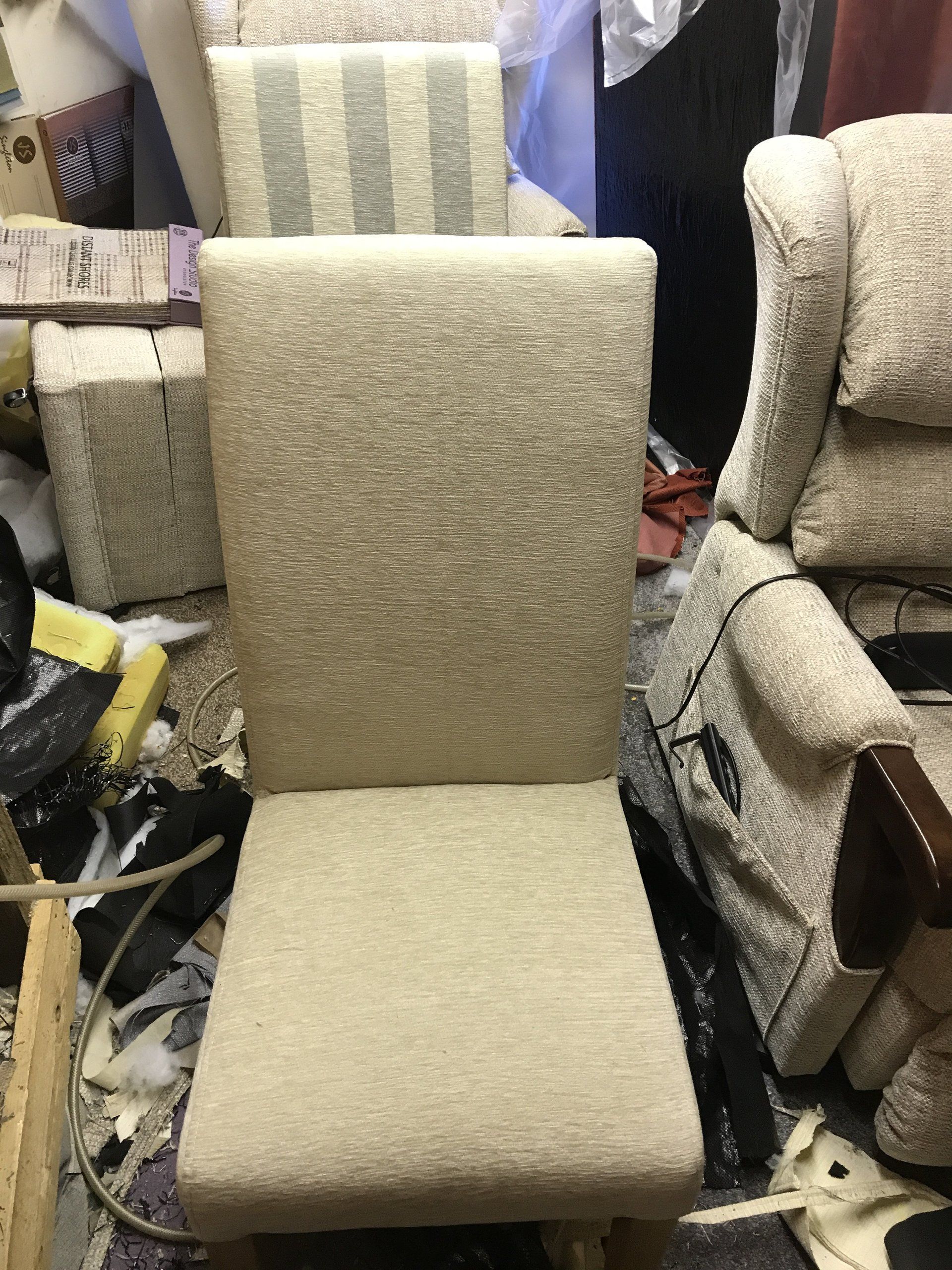 Grey upholstered chair next to matching armchairs