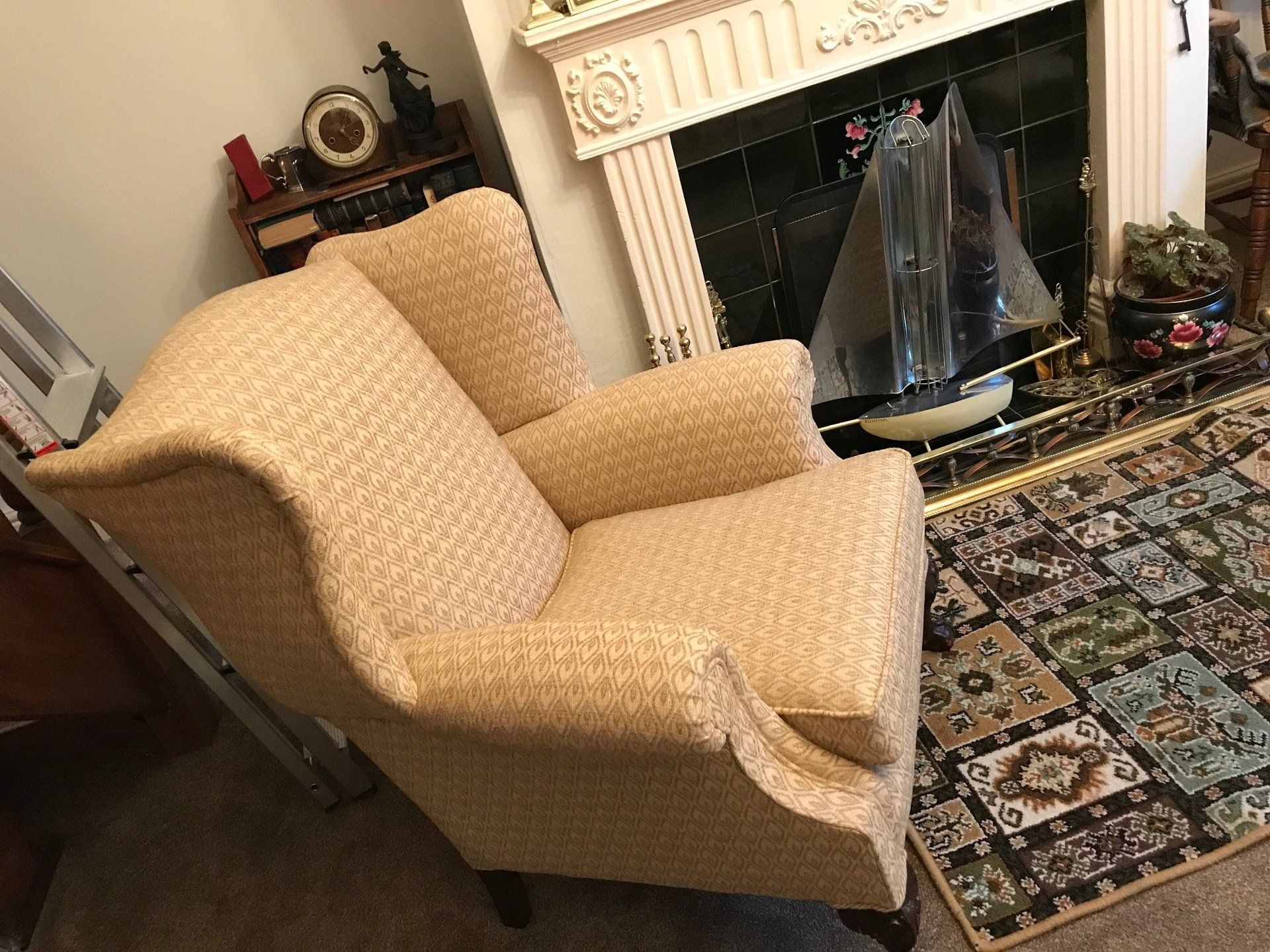 Cream armchair in front of a fireplace