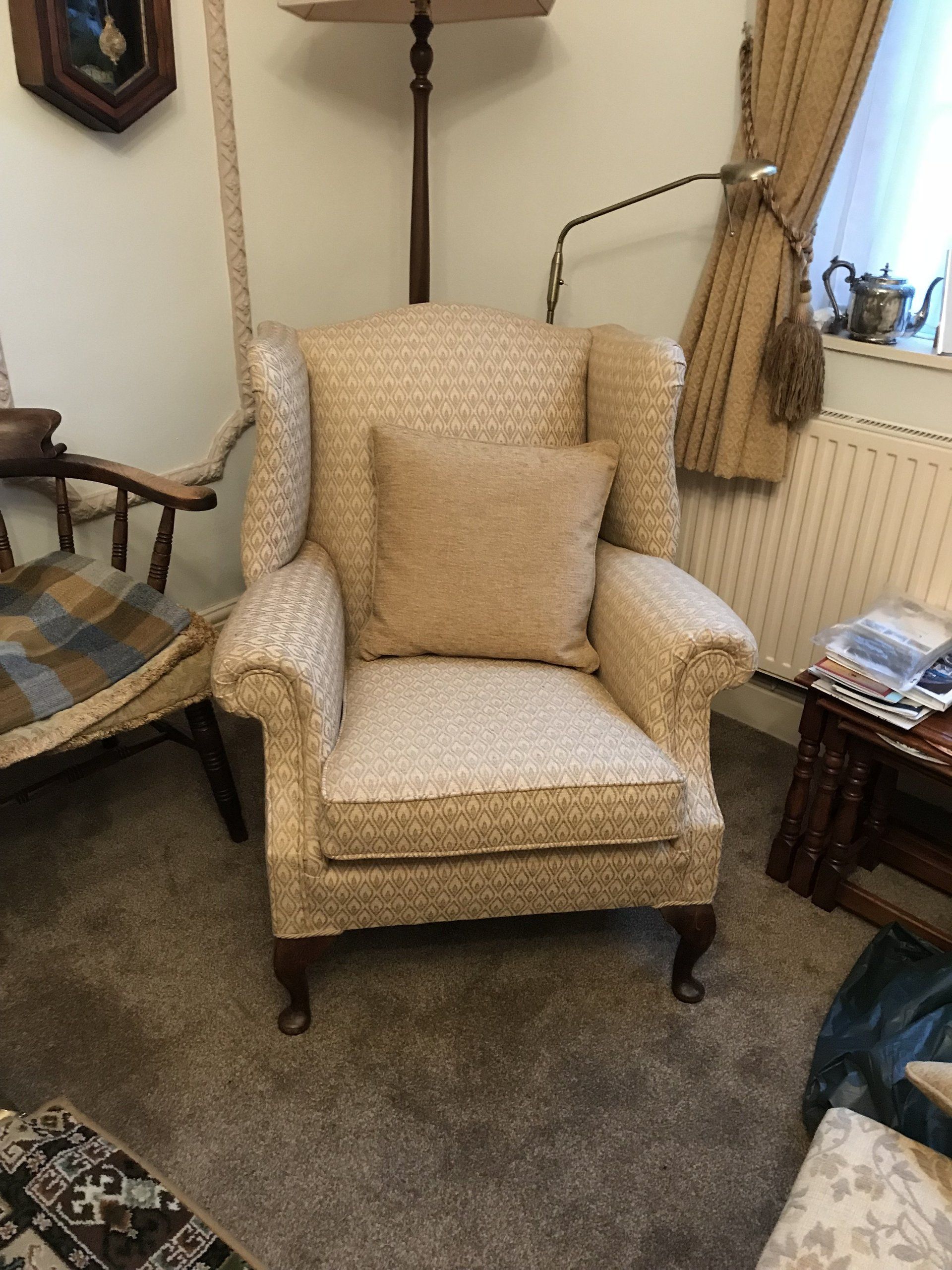 Cream armchair with cushion in a corner