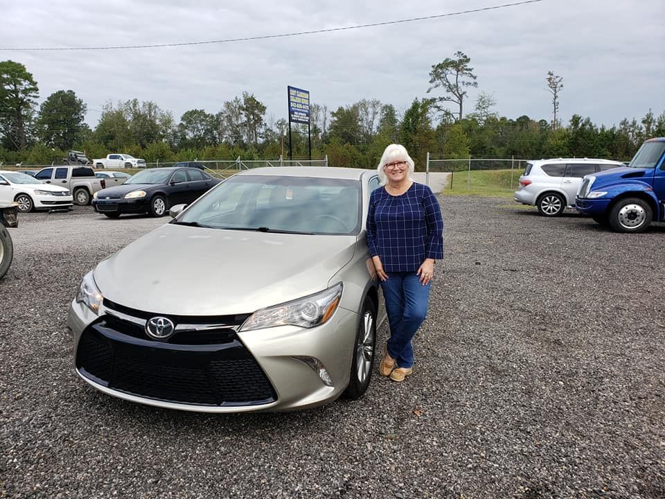 Woman standing next to her Toyota Collora