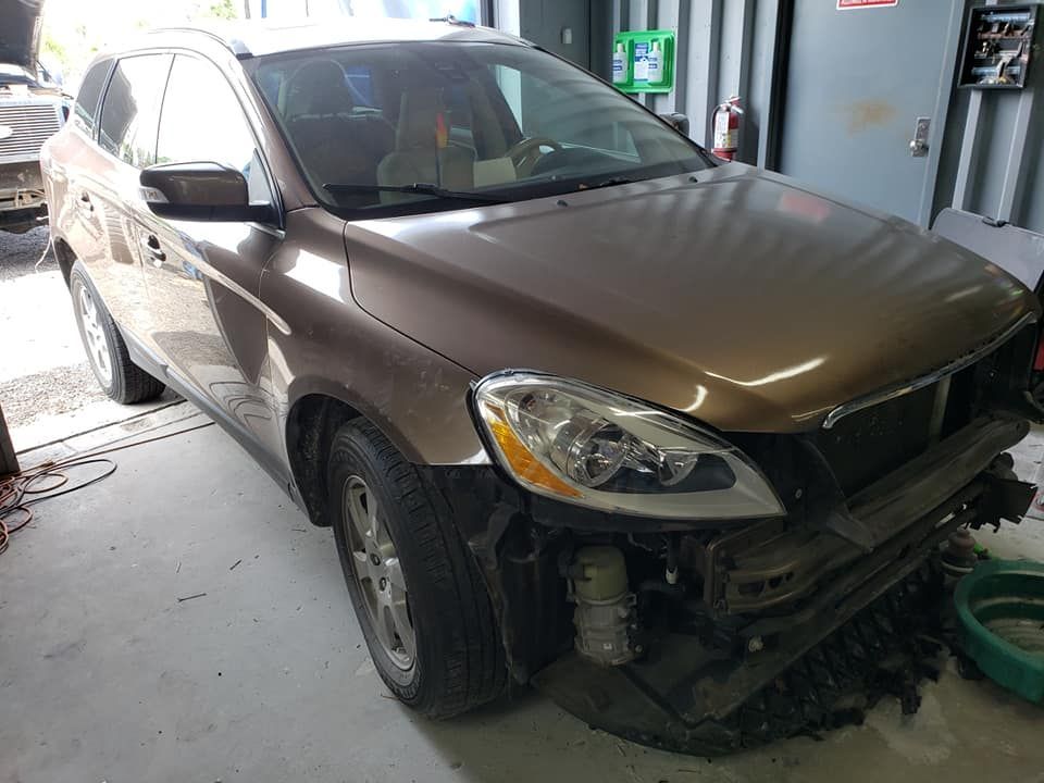 a brown car with the front end removed is parked in a garage .