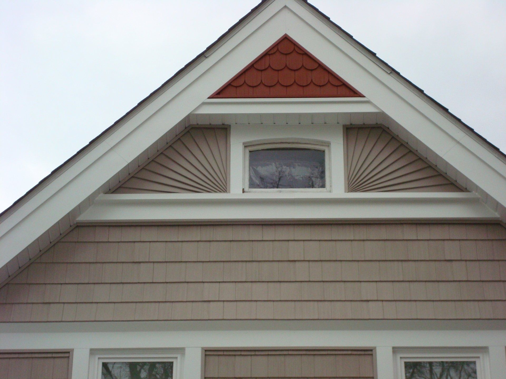 A house with a triangle shaped roof and a window