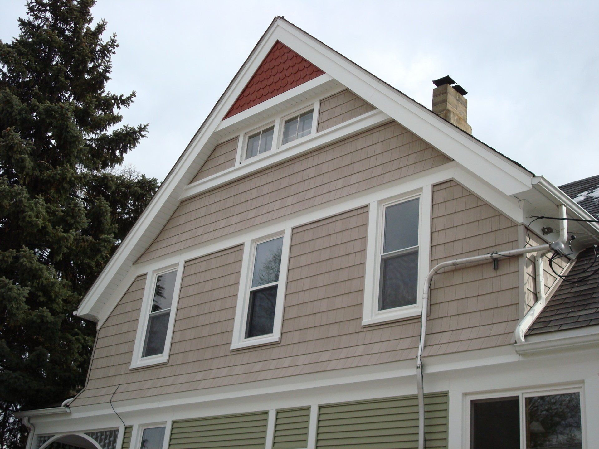 A house with a triangle shaped roof and a chimney