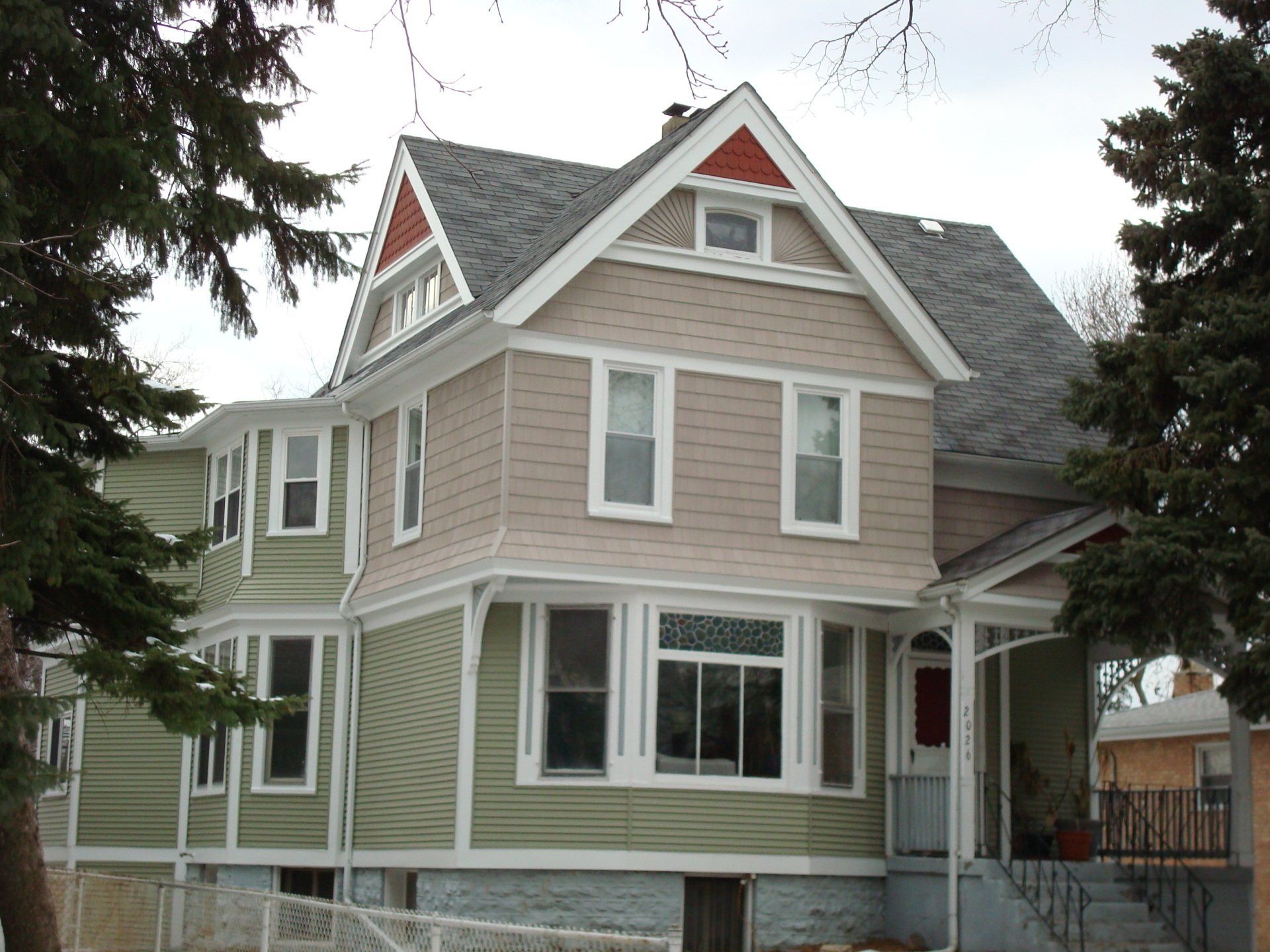 A house with a gray roof and green siding