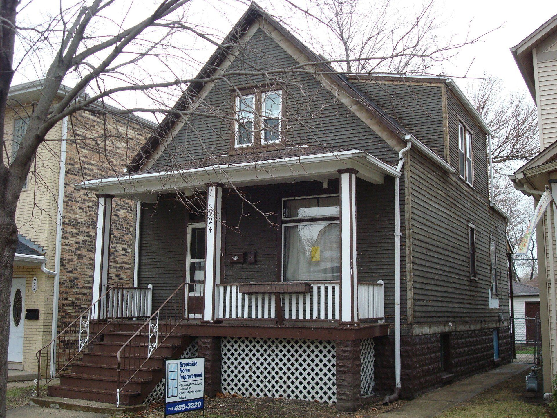 A house with a porch and stairs is for sale