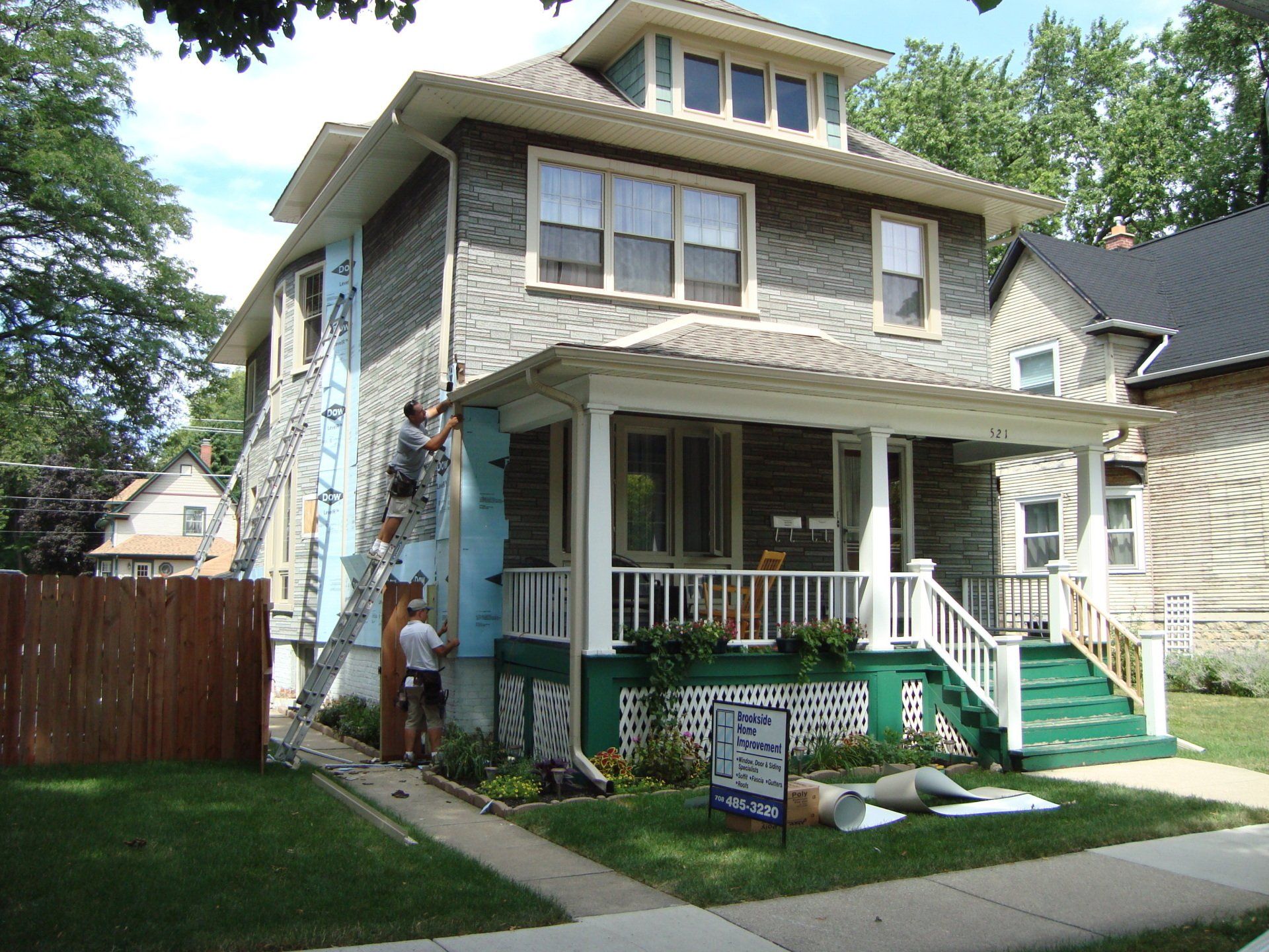 A house that is being painted with a sign in front of it