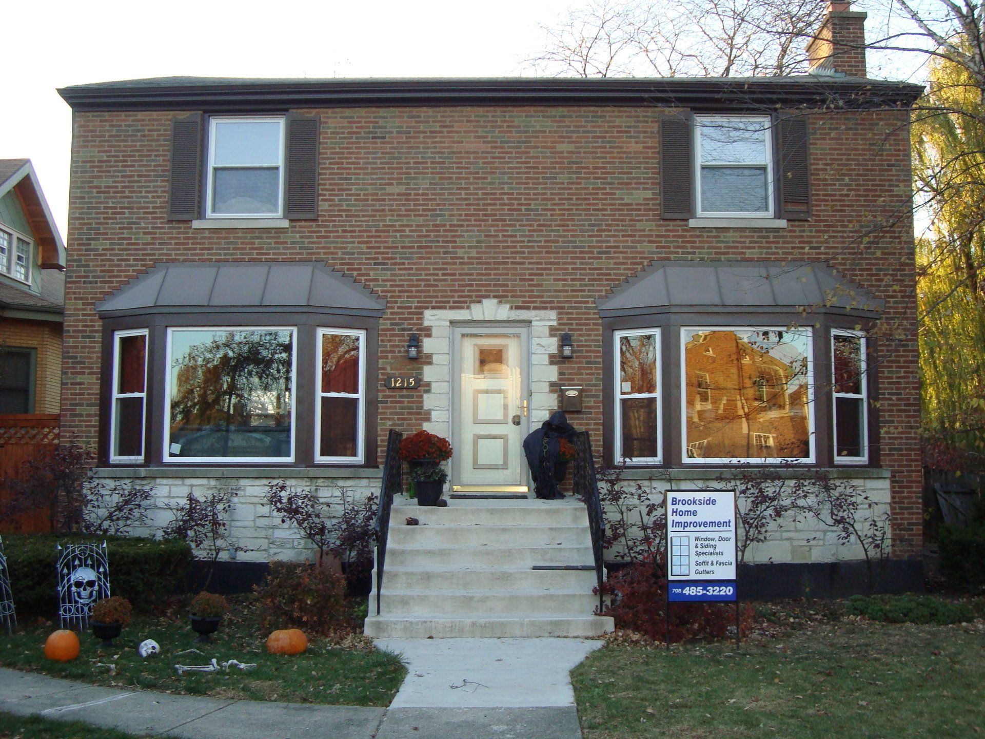 A large brick house with a sign in front of it that says 