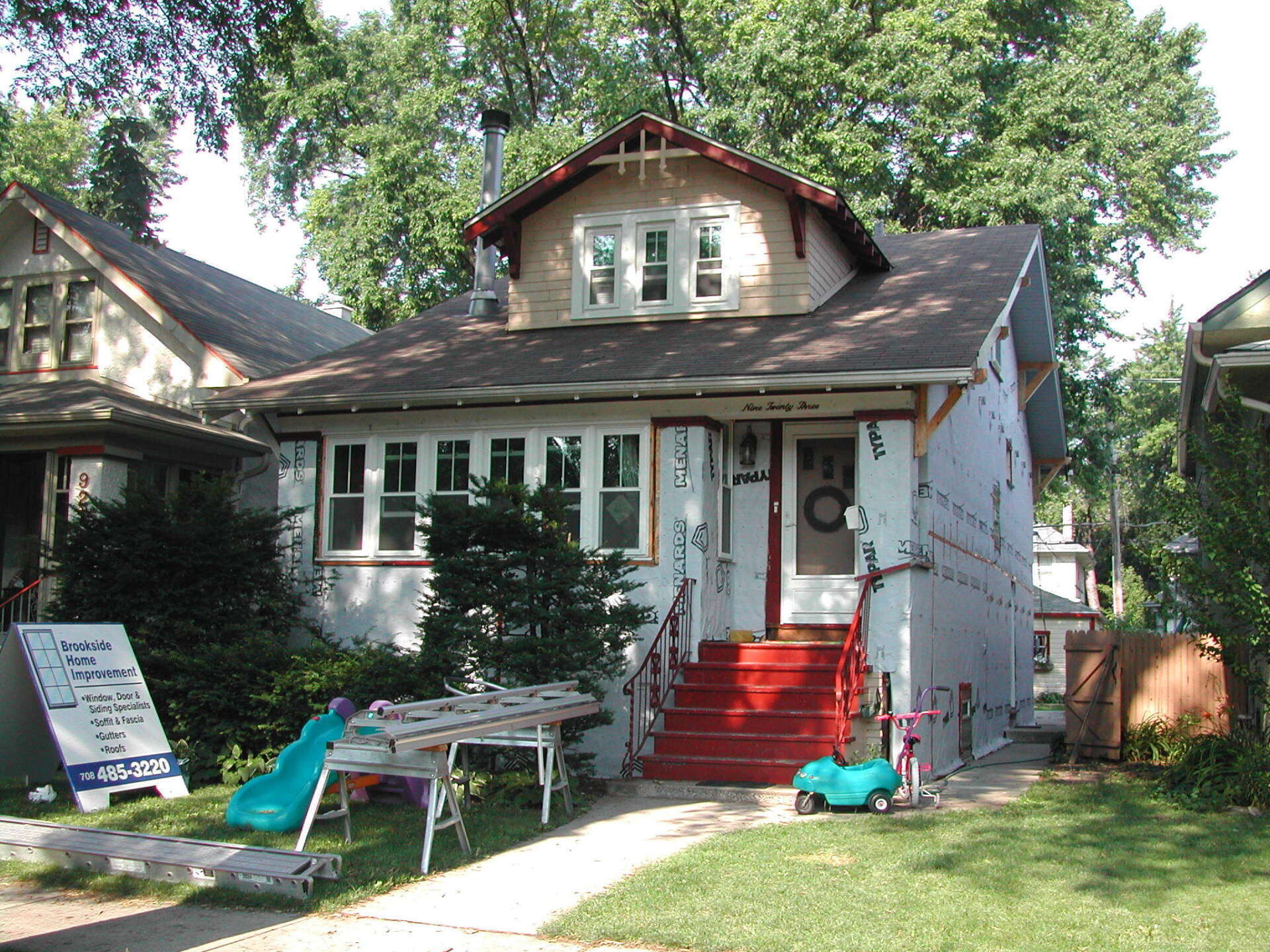 A white house with red stairs and a blue slide