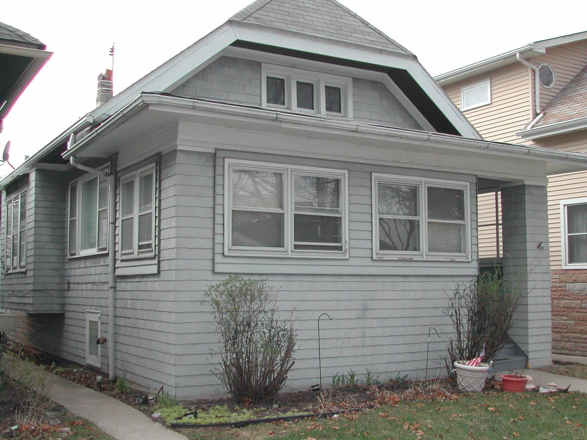 A gray house with a gray roof and many windows