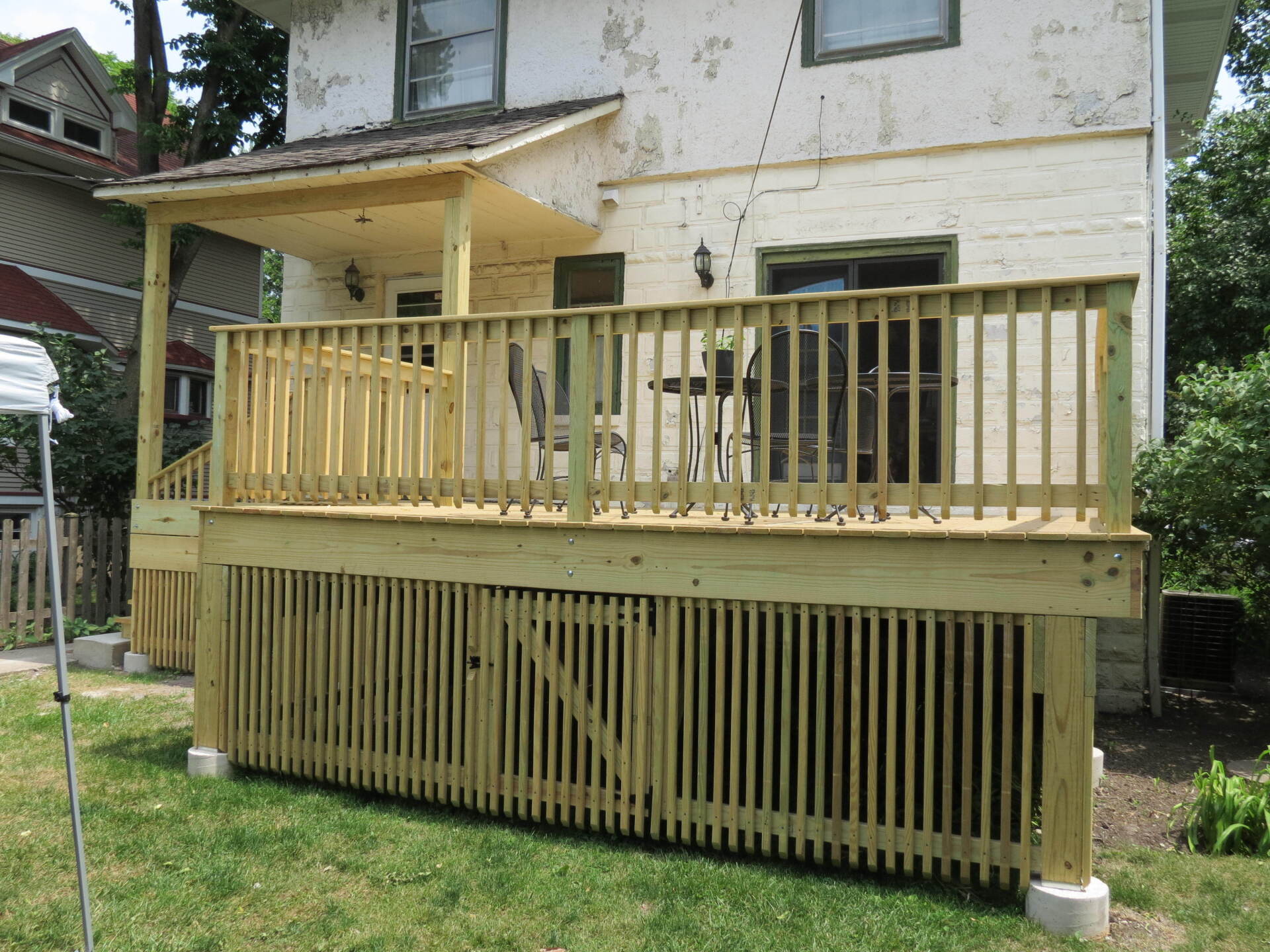 A white house with a wooden deck in front of it