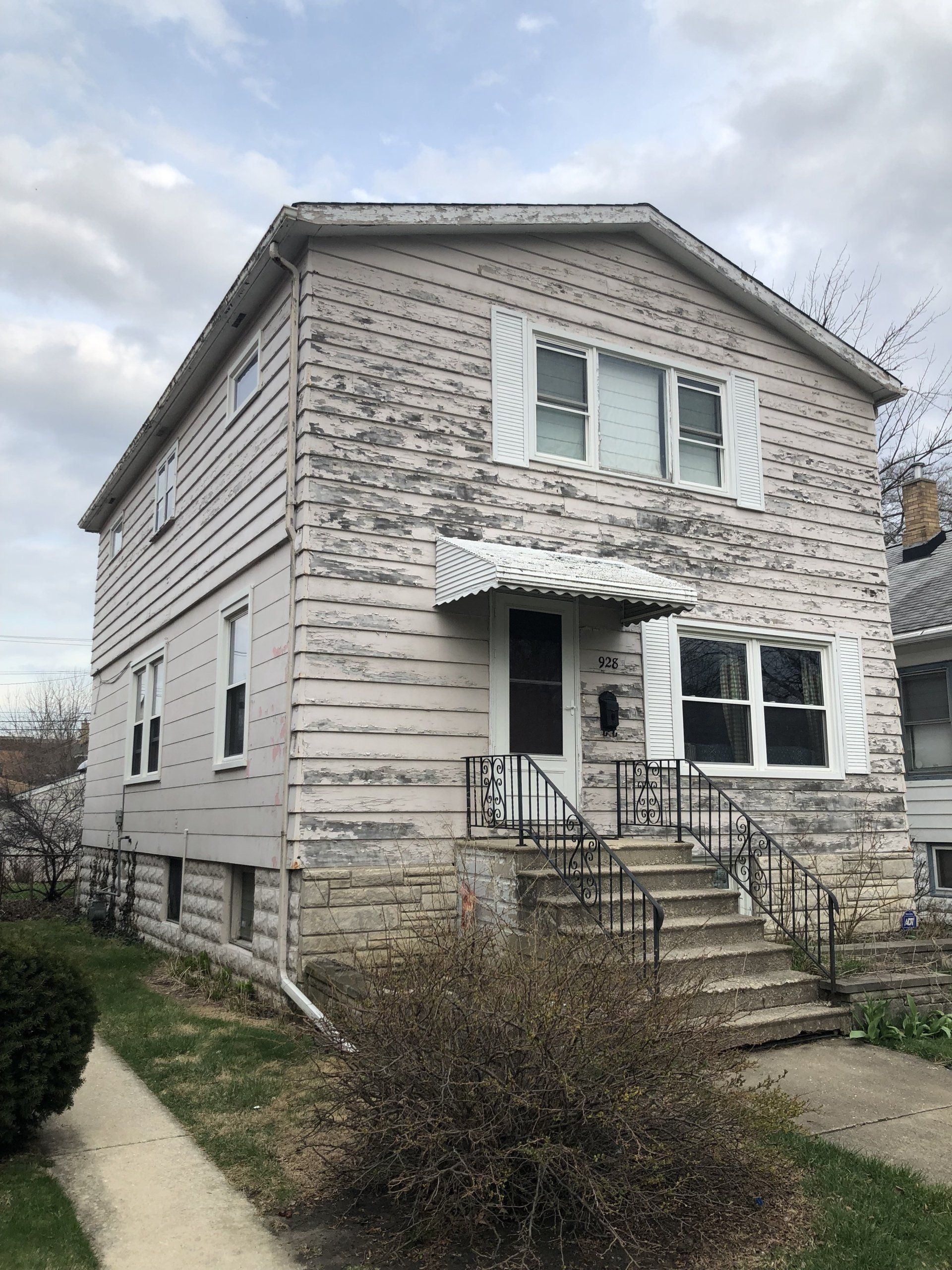 A large brick house with stairs leading up to the front door.