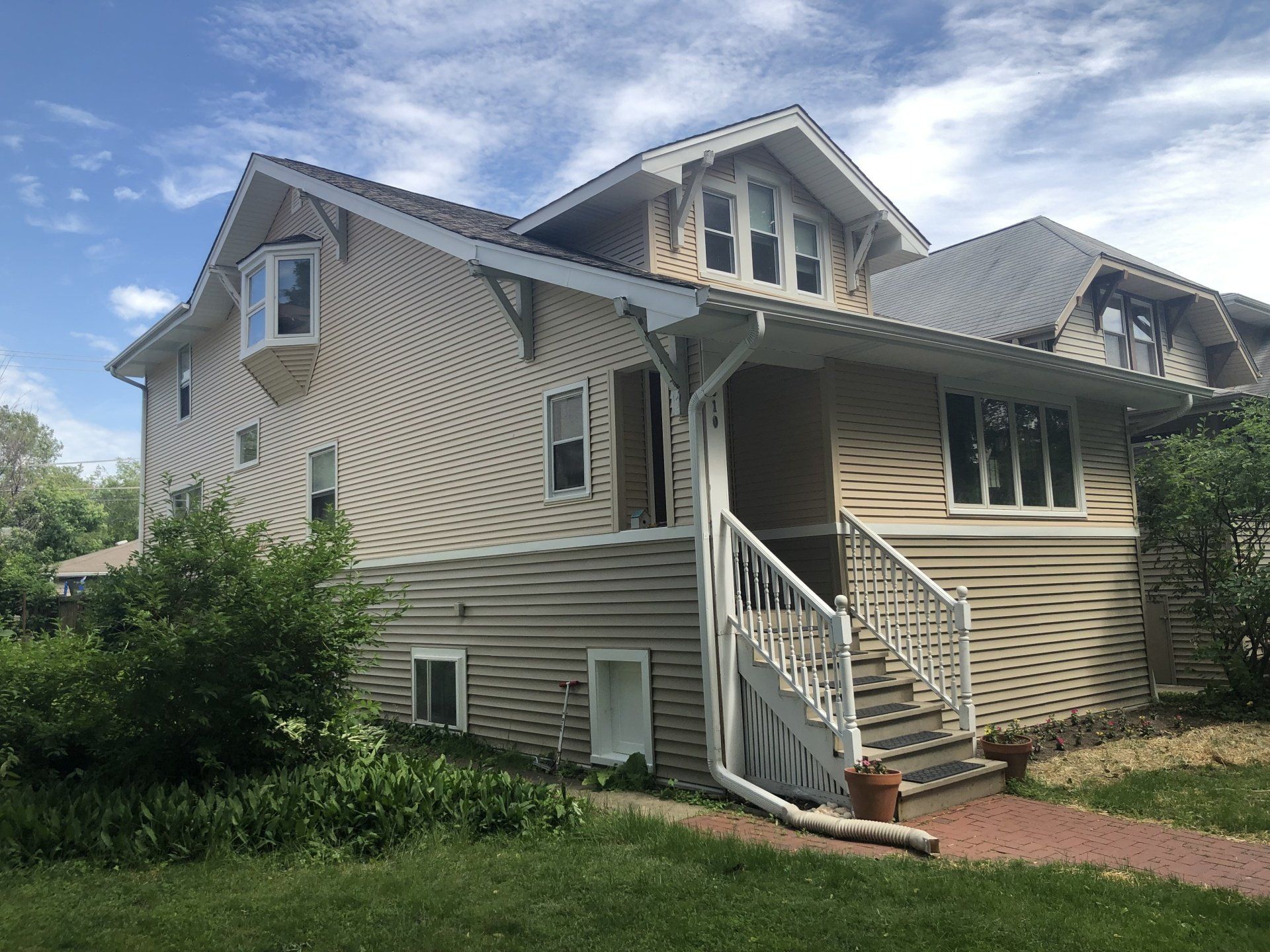 A large house with stairs leading up to the front door.