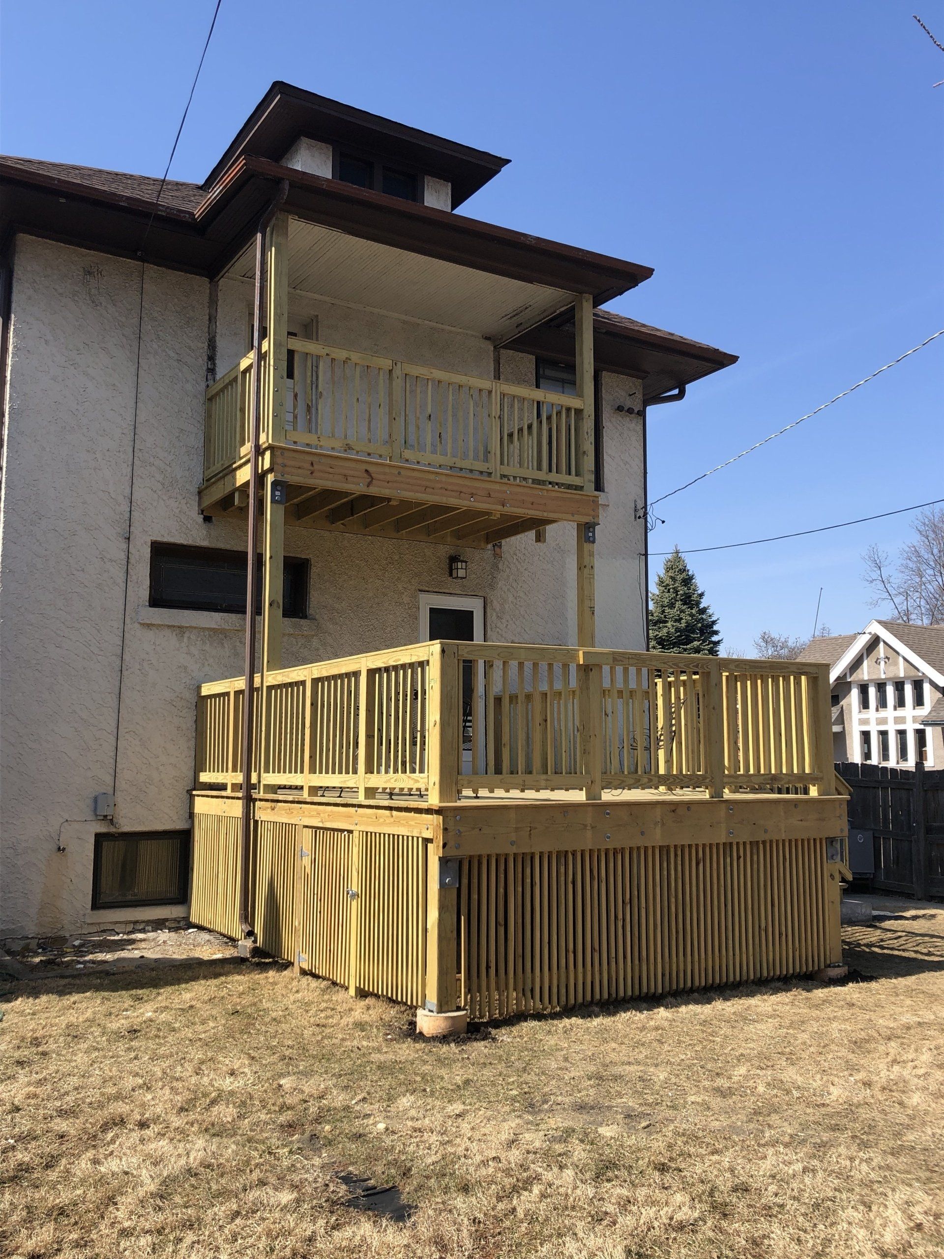 A large house with a wooden deck in front of it