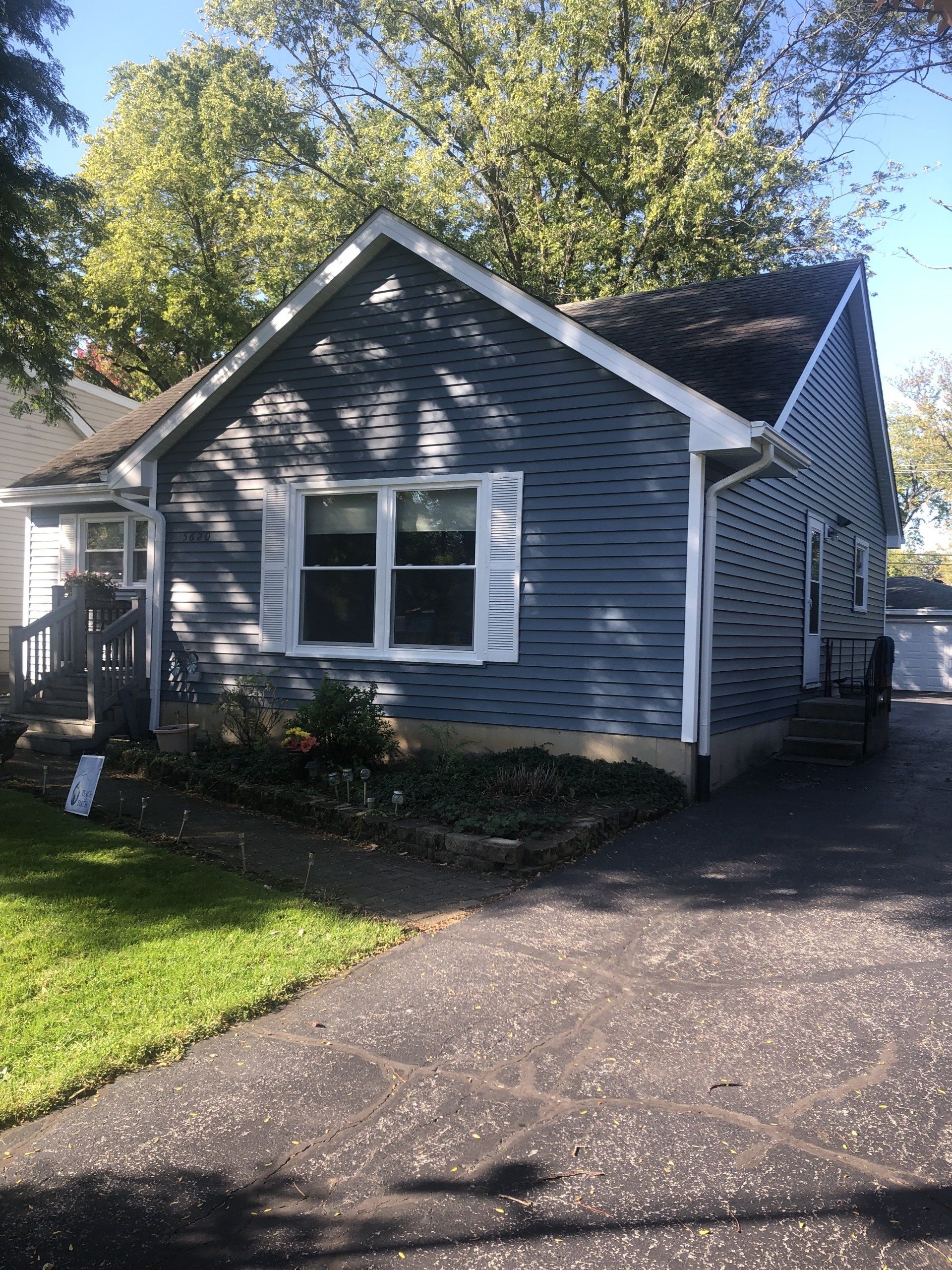 A small house with a driveway in front of it