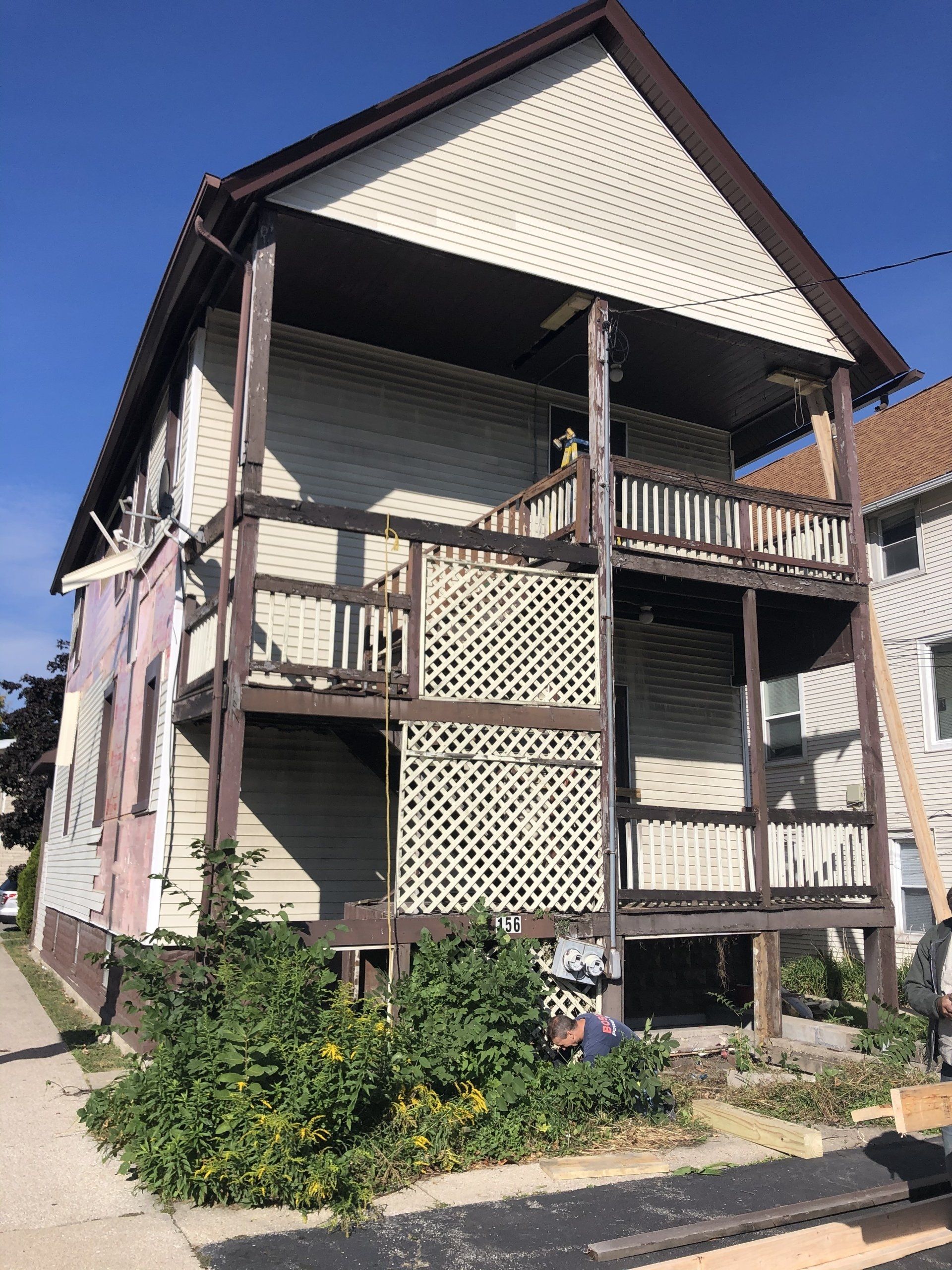 A house with a balcony and a ladder in front of it.