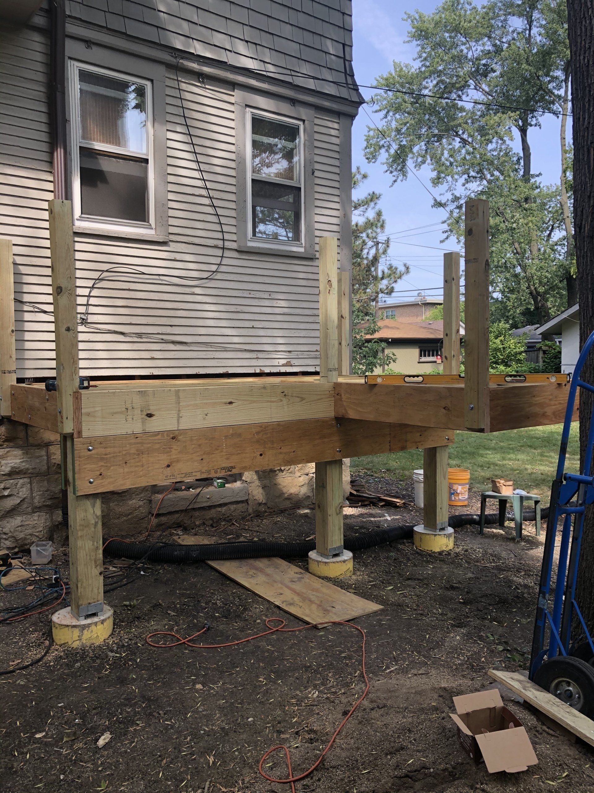 A wooden deck is being built in front of a house.
