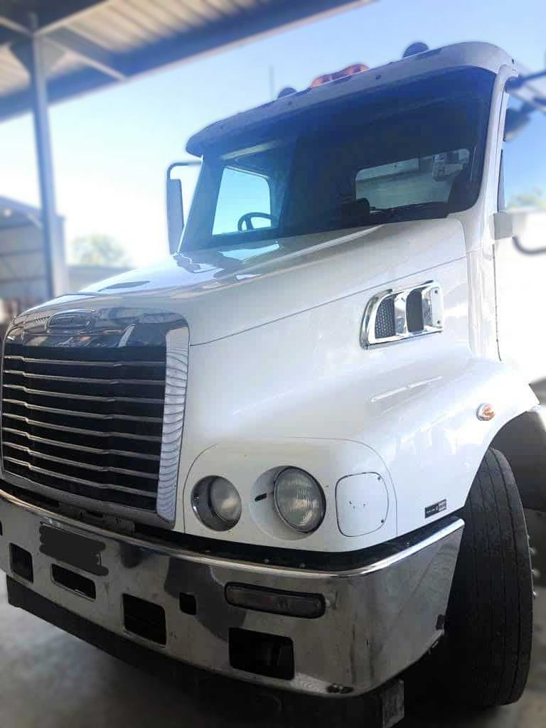 White Mack truck, front view, in a garage.