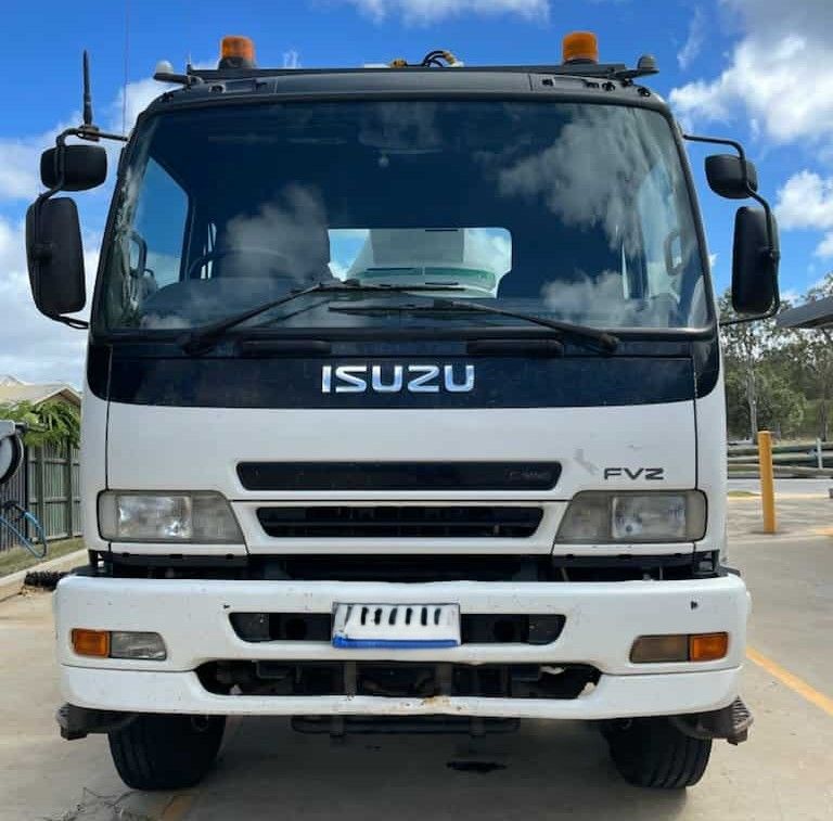 White Isuzu FVZ truck, front view, with black roof, headlights, and license plate.