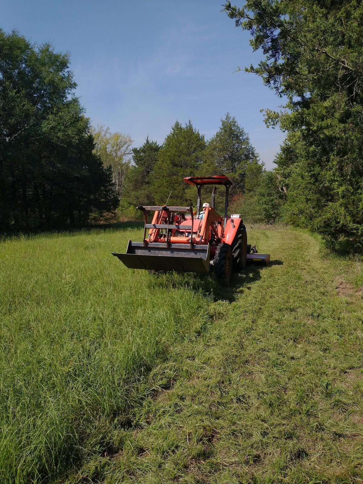 an excavator is digging a pile of dirt in a field