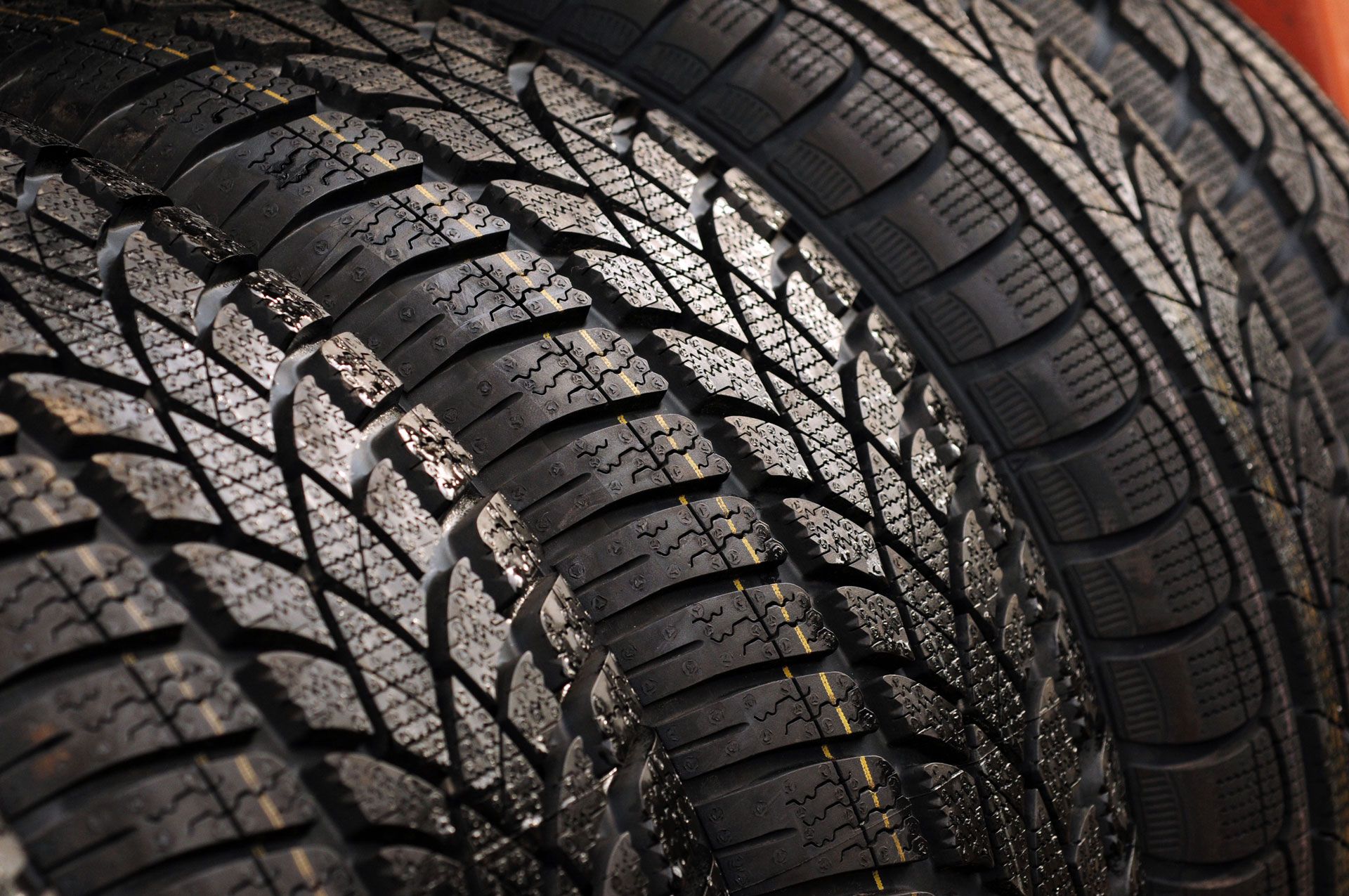 Close-up of three black tires stacked, showing tread patterns.