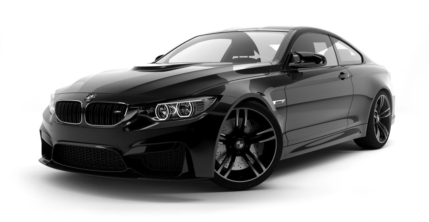 Black BMW M4 coupe parked on a white background.