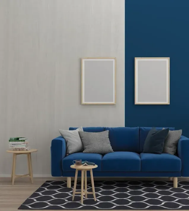 A living room with a blue couch and blue and white walls.