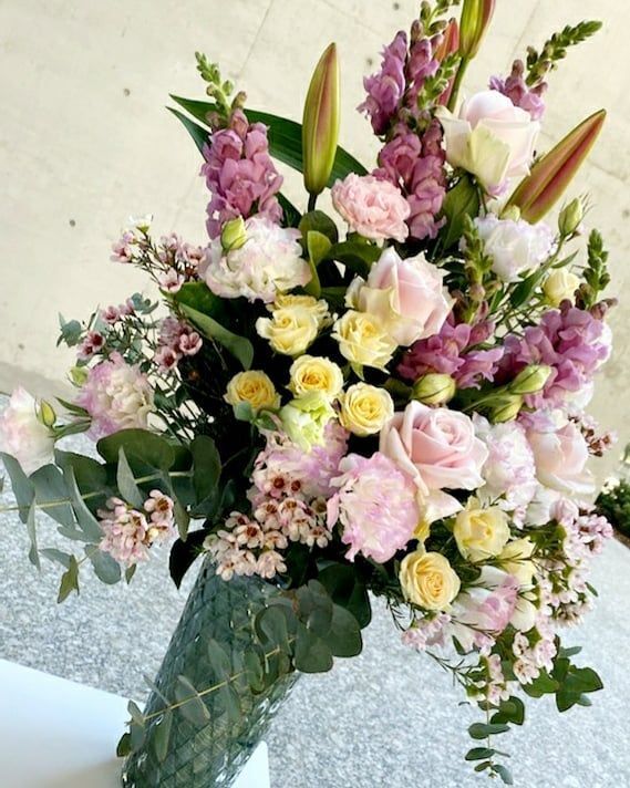 A Vase Filled with Pink and Yellow Flowers Is Sitting on A Table — Ivy Lane Flowers & Gifts in Nambour, QLD