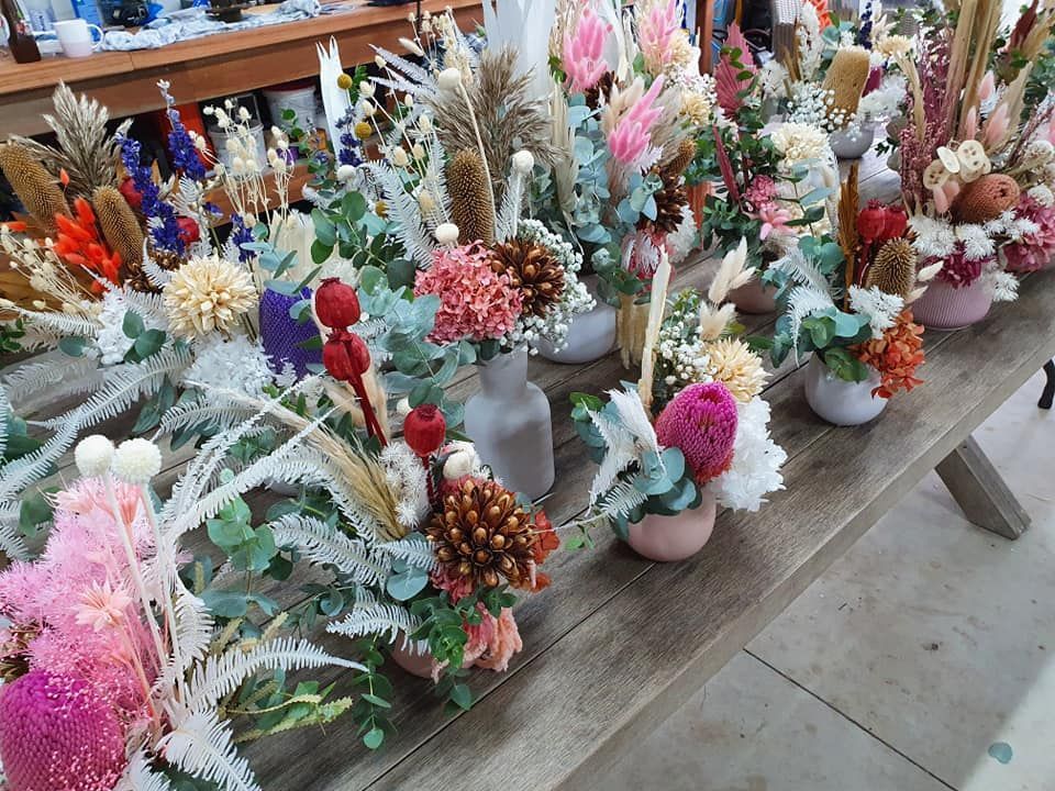 A Wooden Table Topped with Vases Filled with Flowers — Ivy Lane Flowers & Gifts in Buderim, QLD
