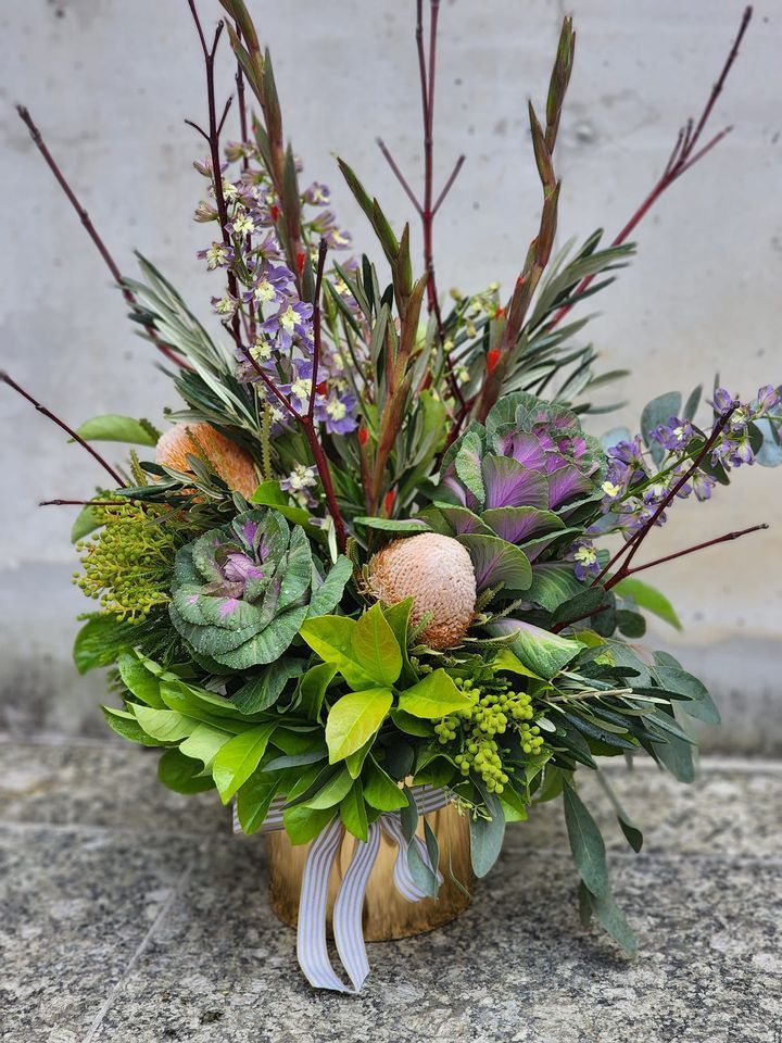 A Vase Filled with Flowers and Leaves Is Sitting on The Ground — Ivy Lane Flowers & Gifts in Birtinya, QLD