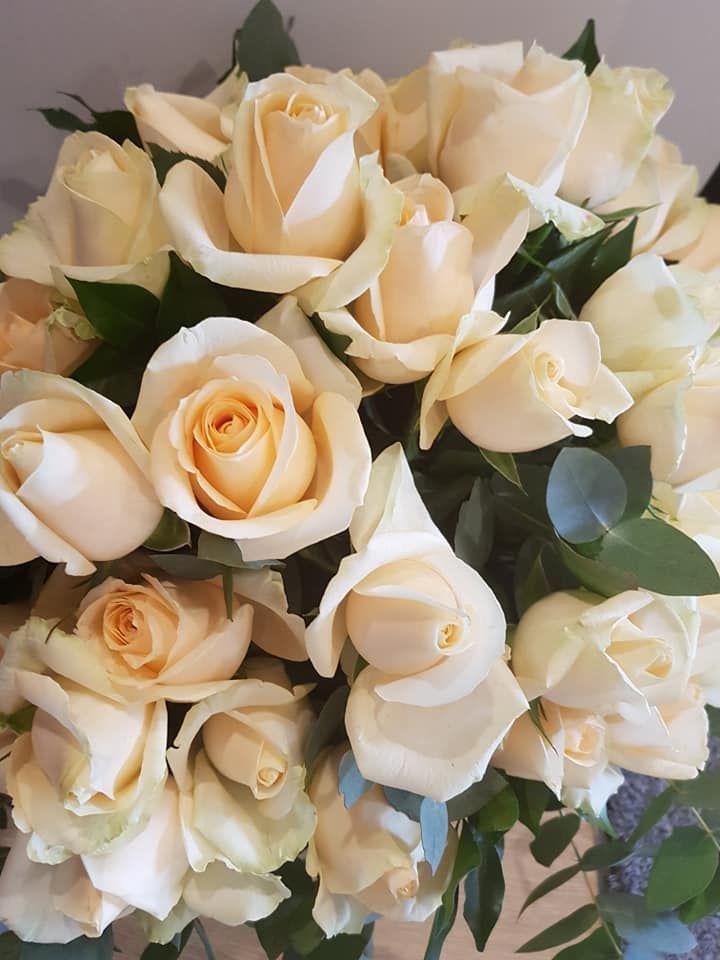 A Bouquet of White Roses with Green Leaves on A Table — Ivy Lane Flowers & Gifts in Sunshine Coast, QLD