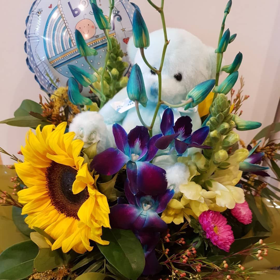 A Teddy Bear Is Sitting in A Bouquet — Ivy Lane Flowers & Gifts in Maroochydore, QLD