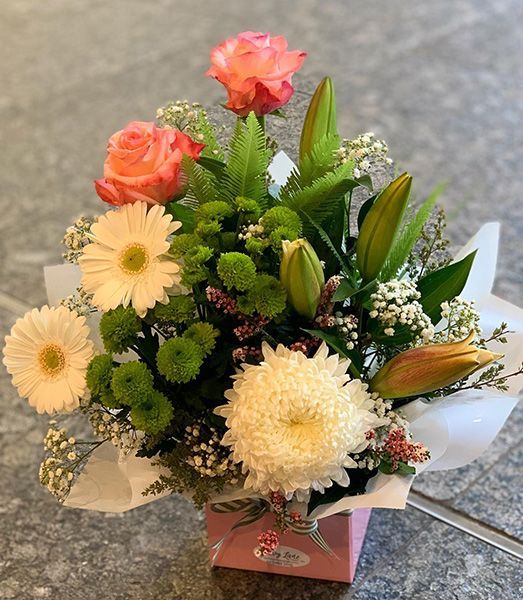 A Pink Box Filled with Flowers Is Sitting on A Table — Ivy Lane Flowers & Gifts in Mooloolaba, QLD