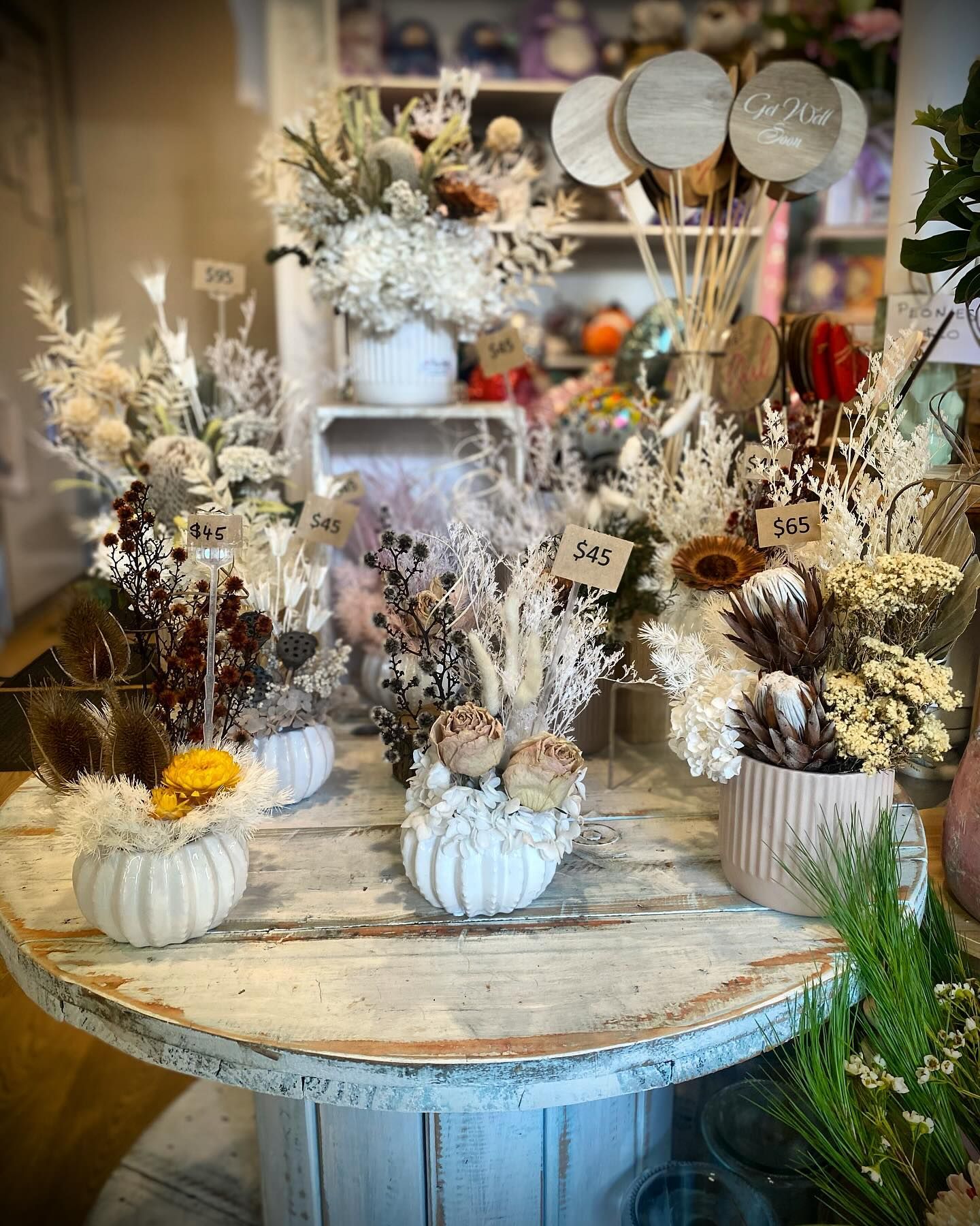 Display of Dried Flower Arrangements on a Rustic Table — Ivy Lane Flowers and Gifts in Sunshine Coast