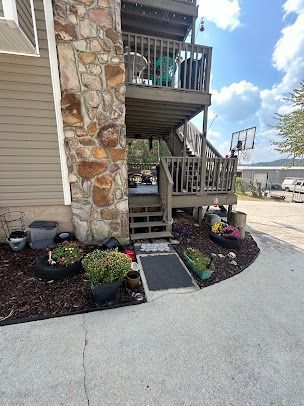 Building exterior with stone column, wooden decks, and landscaping.