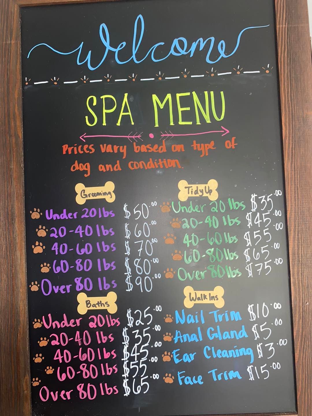 A woman is standing next to a dog on a grooming table.