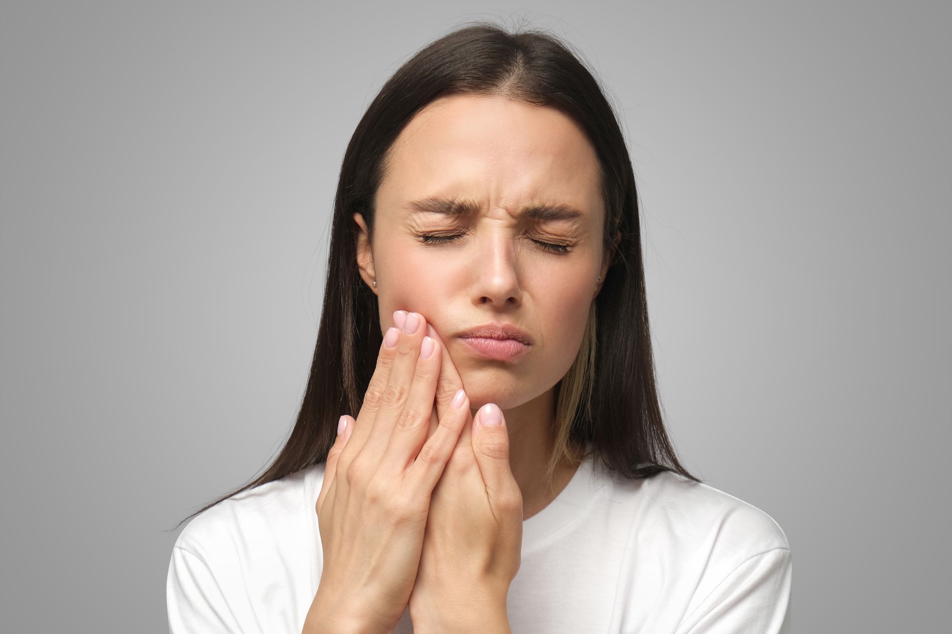 woman holding mouth in pain | same day emergency family dentist in Somerset NJ