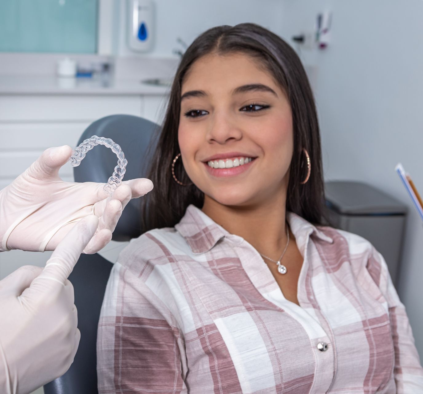 woman smiling looking at clear aligners | Aetna, Cigna Dentist with affordable plans | Somerset, NJ