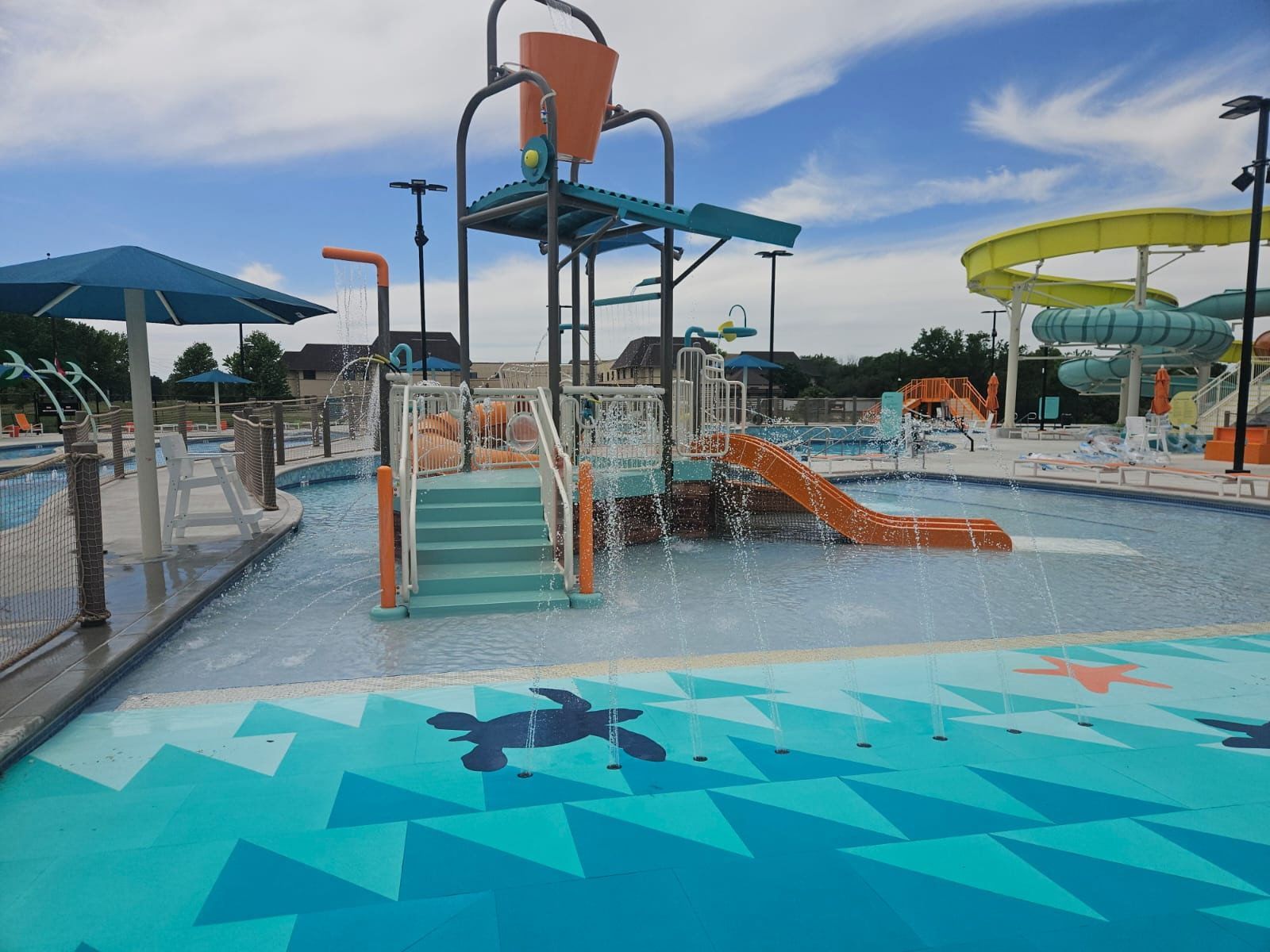 A water park with a turtle on the floor and a water slide.