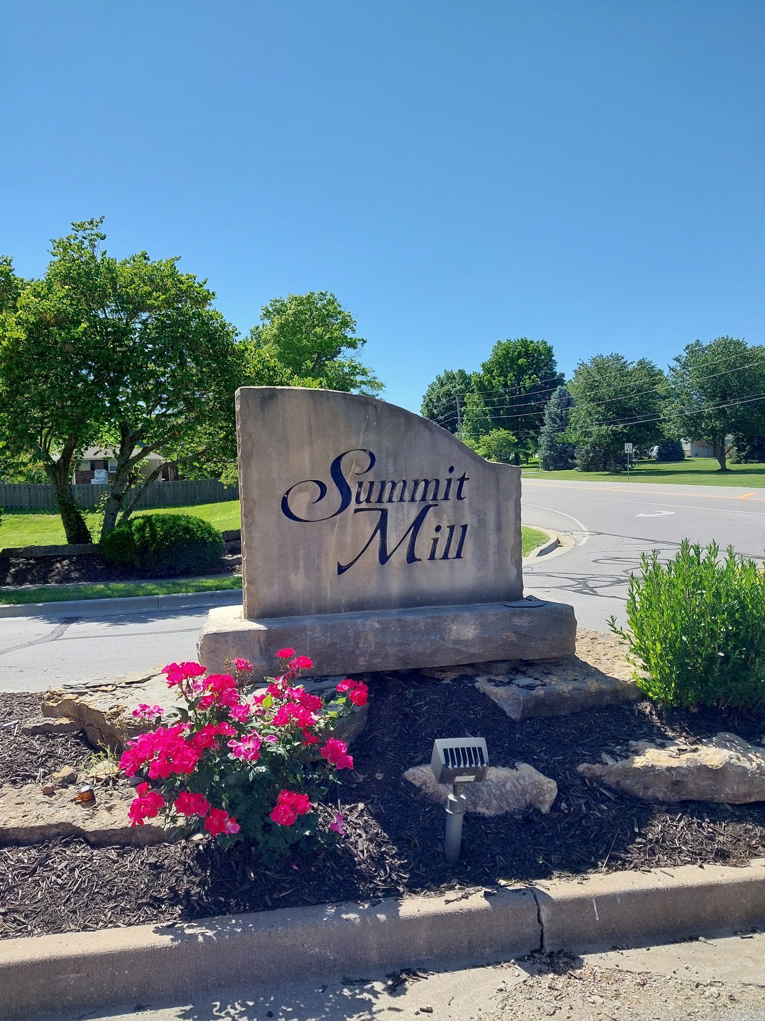 A stone wall with a sign that says ravenwood place