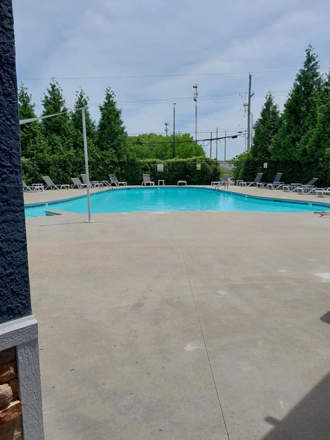A large swimming pool surrounded by chairs and trees