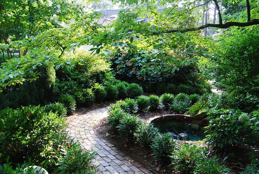 garden space with brick pathway and round pond sod installation Willow Springs, NC