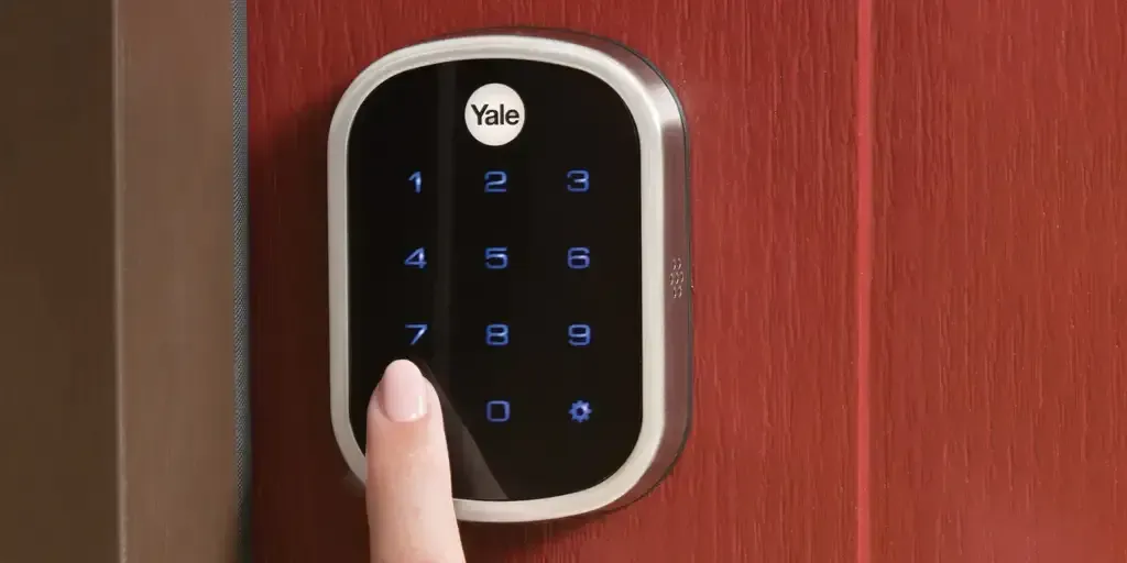 A person is pressing a button on a smart door lock.