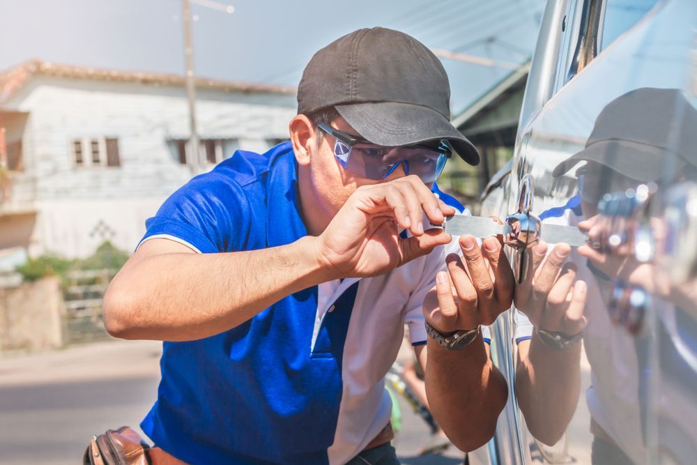 A man is using a key to open a car door.