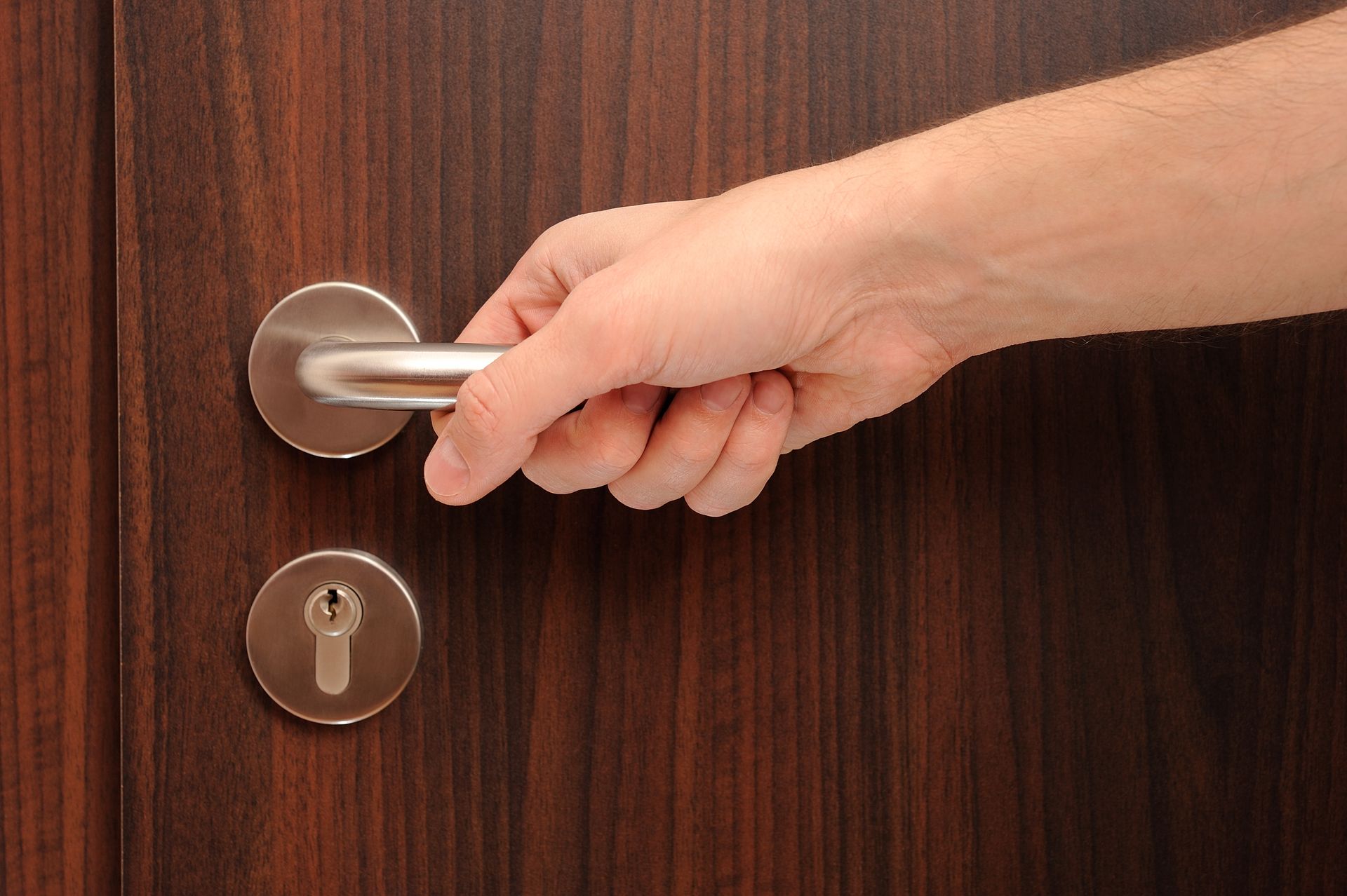 A close up of a person 's hand holding a door handle.